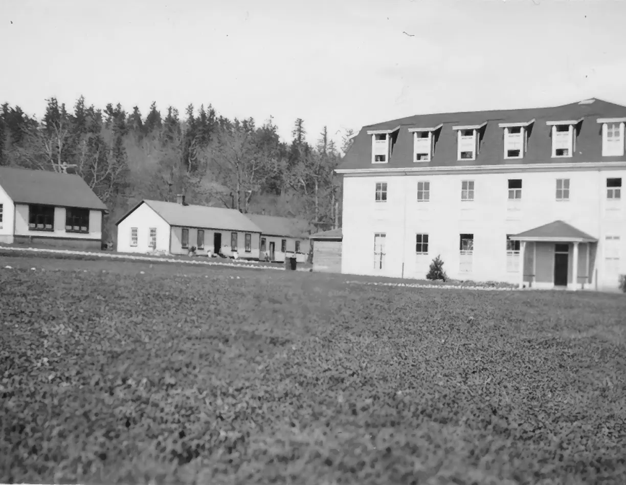 A black and white photo of a farm house.