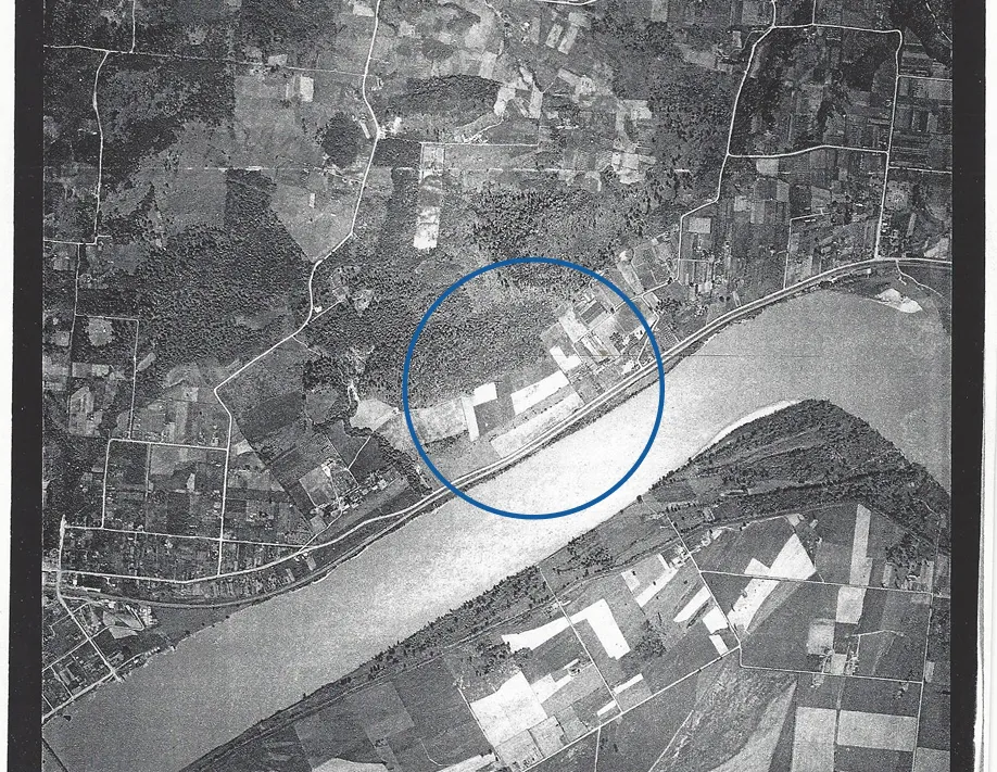 A black and white photo of a river and land.