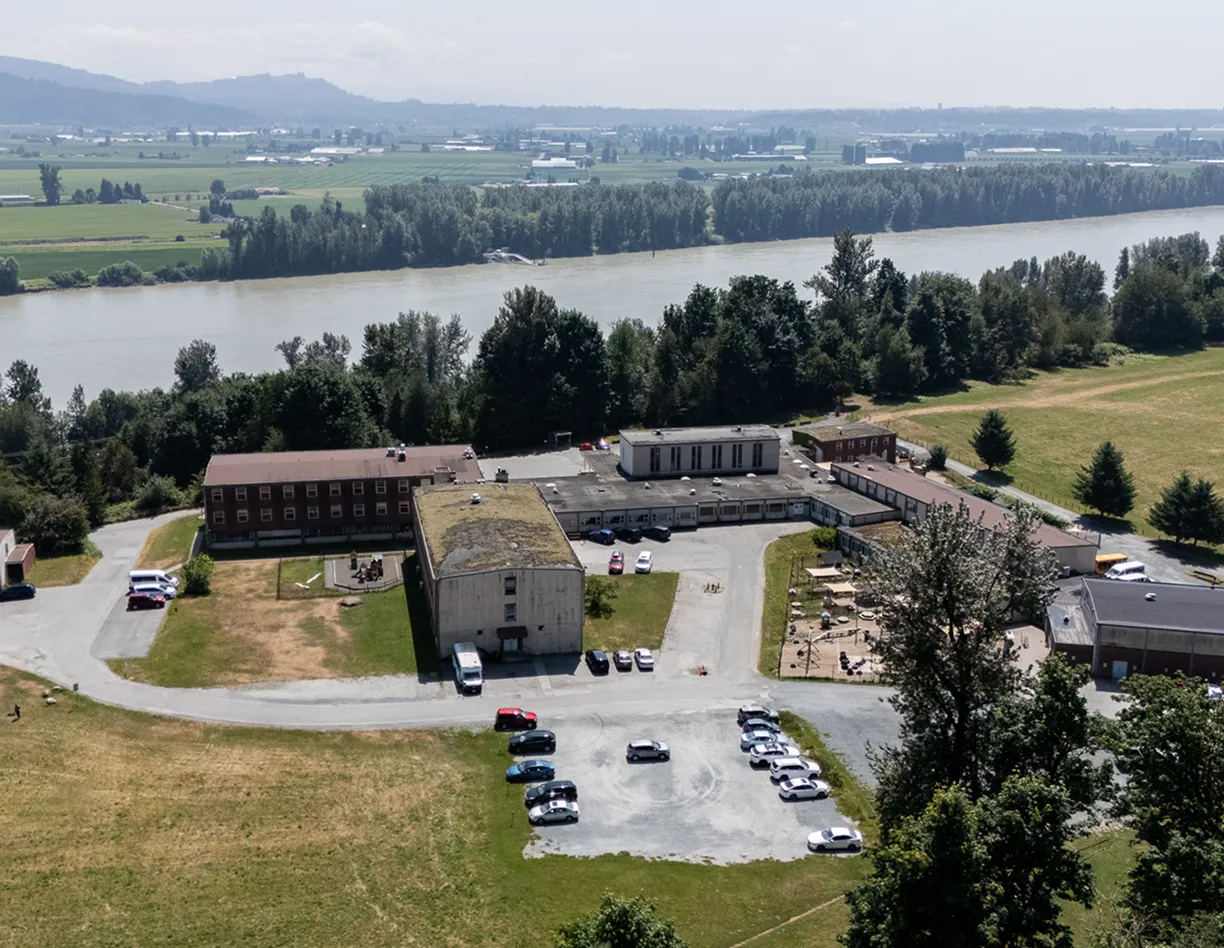 An aerial view of a parking lot with a river in the background.