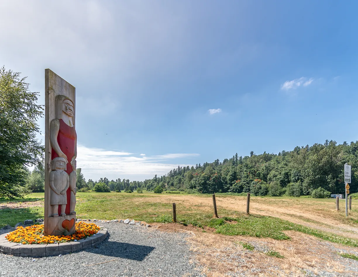 A large wooden carving of a man in a field.