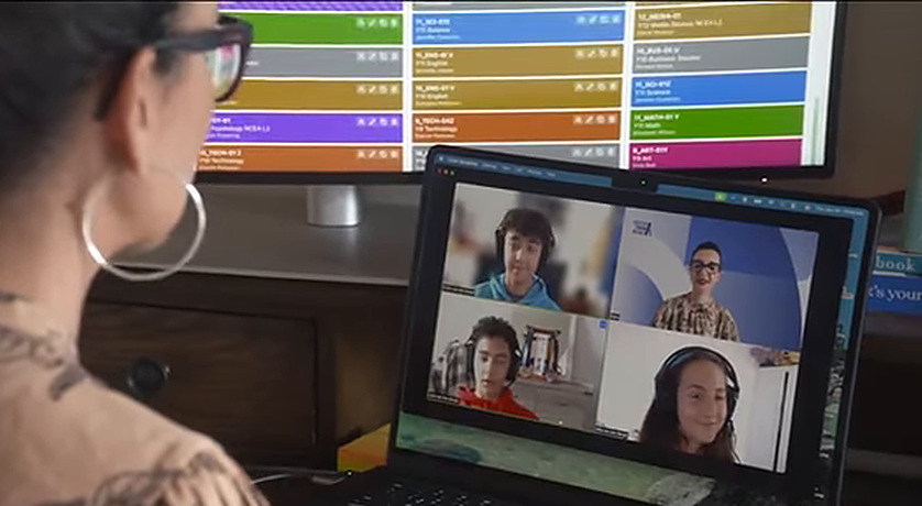 A colour-coded class timetable on screen beside a live online lesson