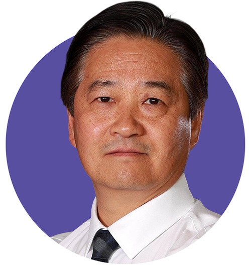 Middle-aged man with black hair wearing a white shirt and dark striped tie against a purple circular background.