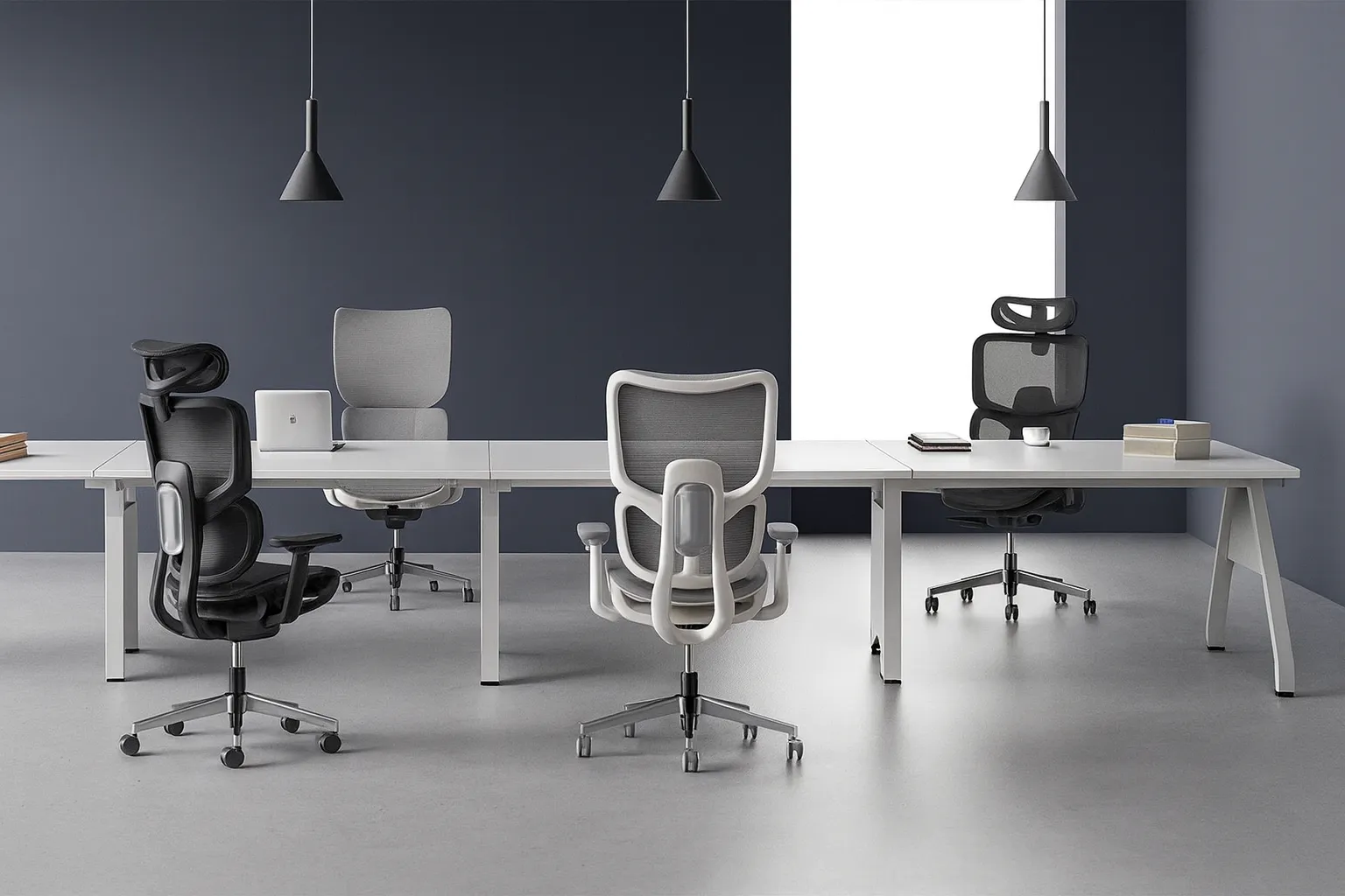 Modern office with white desks and ergonomic black and gray mesh chairs under pendant lights.