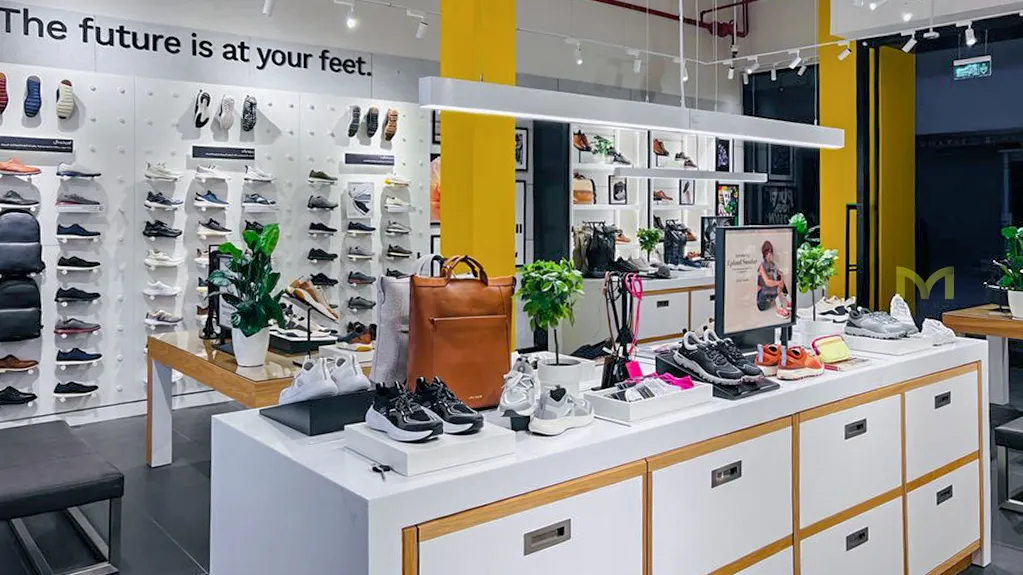 Modern shoe store interior with white sneakers, a brown bag, and the slogan 'The future is at your feet'.