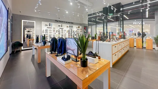 Modern retail store with shoes, accessories on wooden tables and shelves under bright lighting.