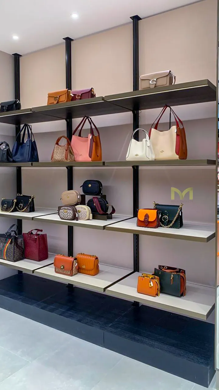 Shelves displaying various handbags in different colors and styles in a retail store.