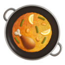 Plat de paella avec poulet, citron et légumes dans une poêle noire avec poignées.