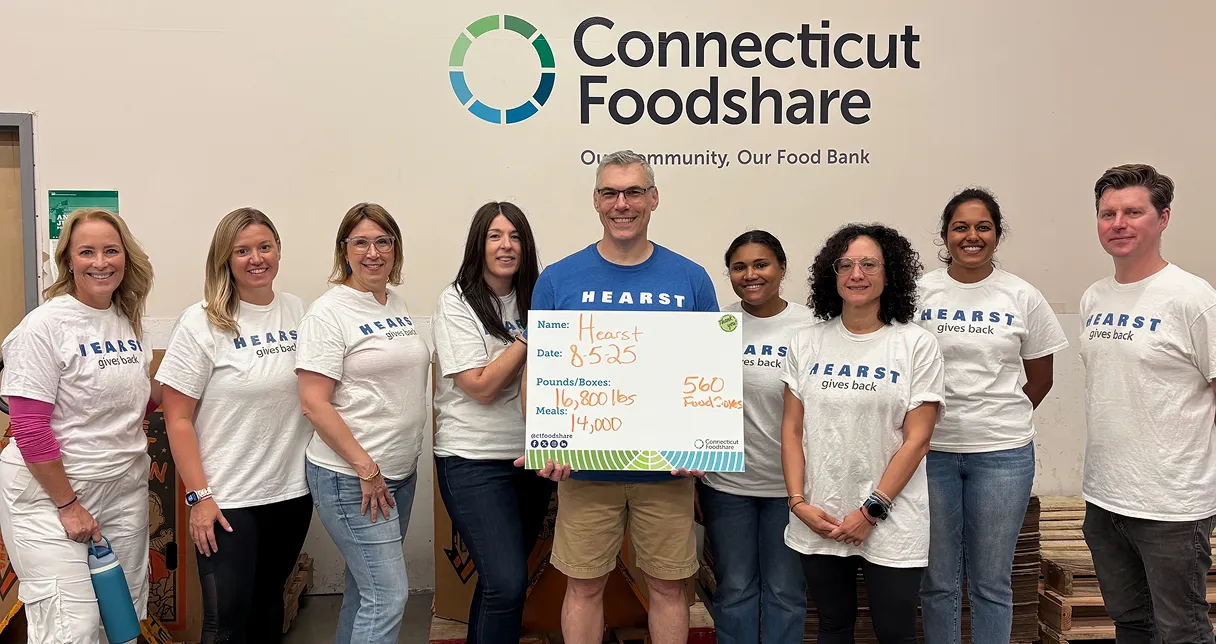 HCMG colleagues holding check.