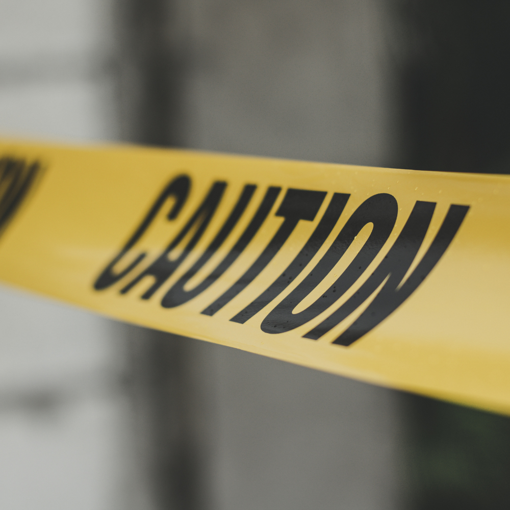 Yellow caution tape with black lettering stretched across an area.