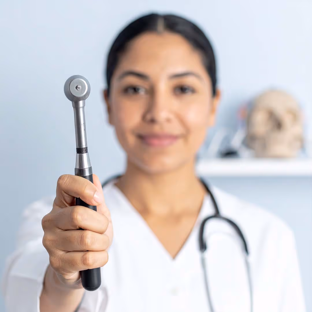 Neurologin hält ein Gerät in die Kamera, mit dem man die Gehirnströme messen kann.