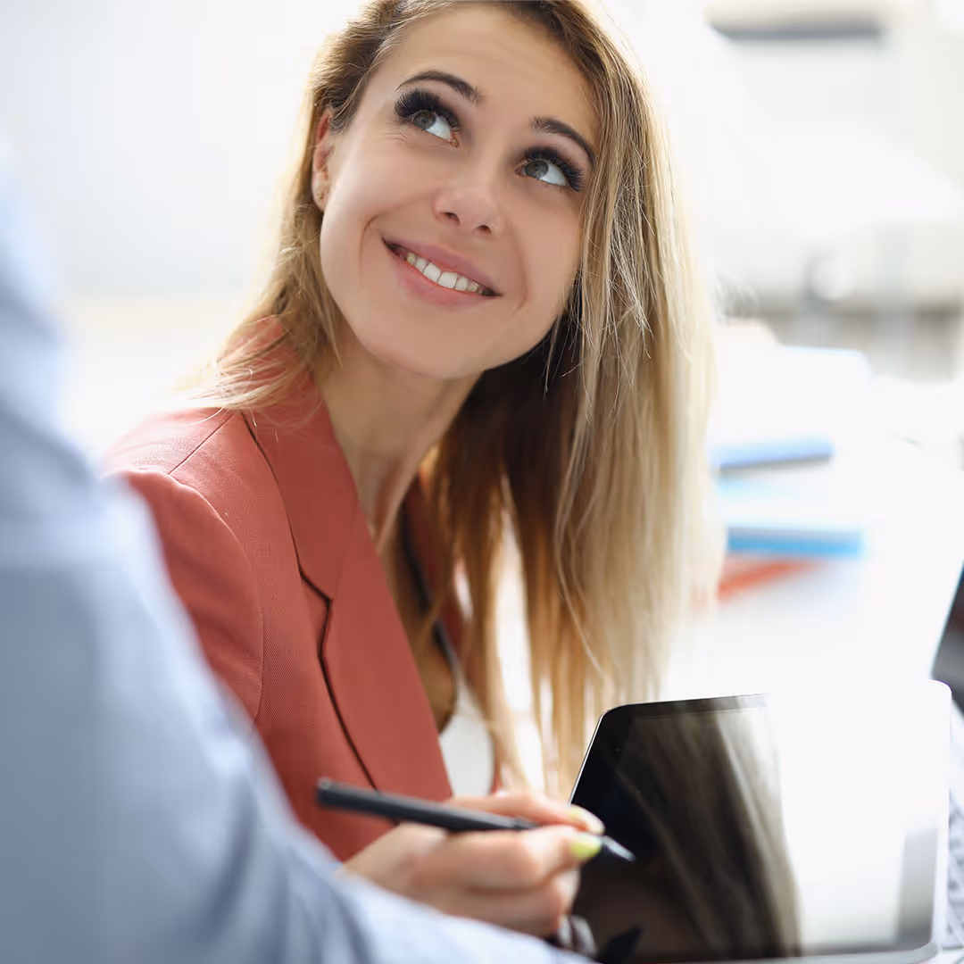 Mitarbeiterin schaut freundlich in die Kamera.