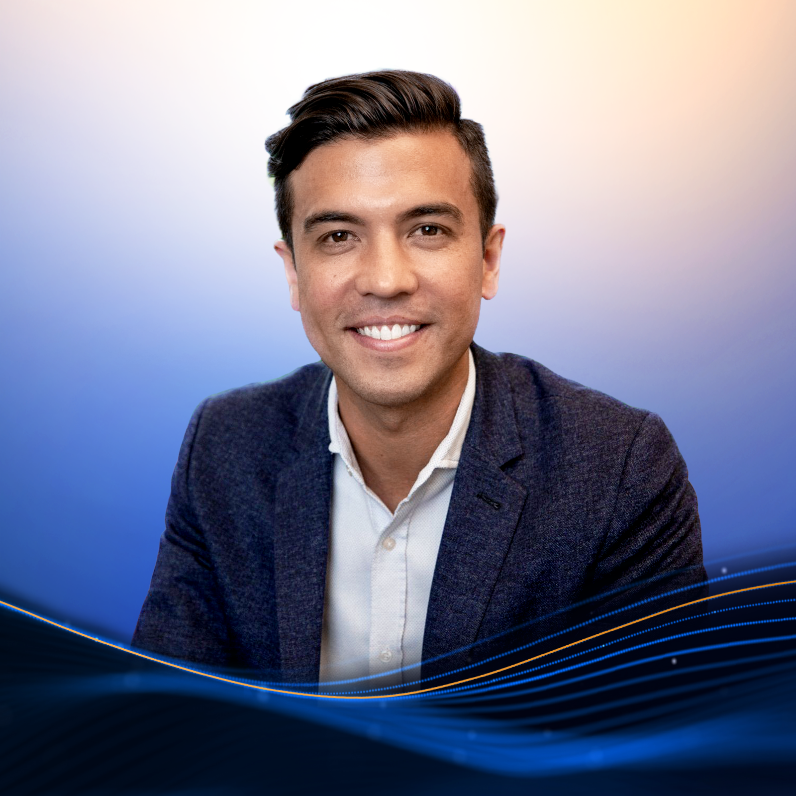 Smiling man with dark hair wearing a navy blazer and white shirt against a blue and orange gradient background with wave-like lines.