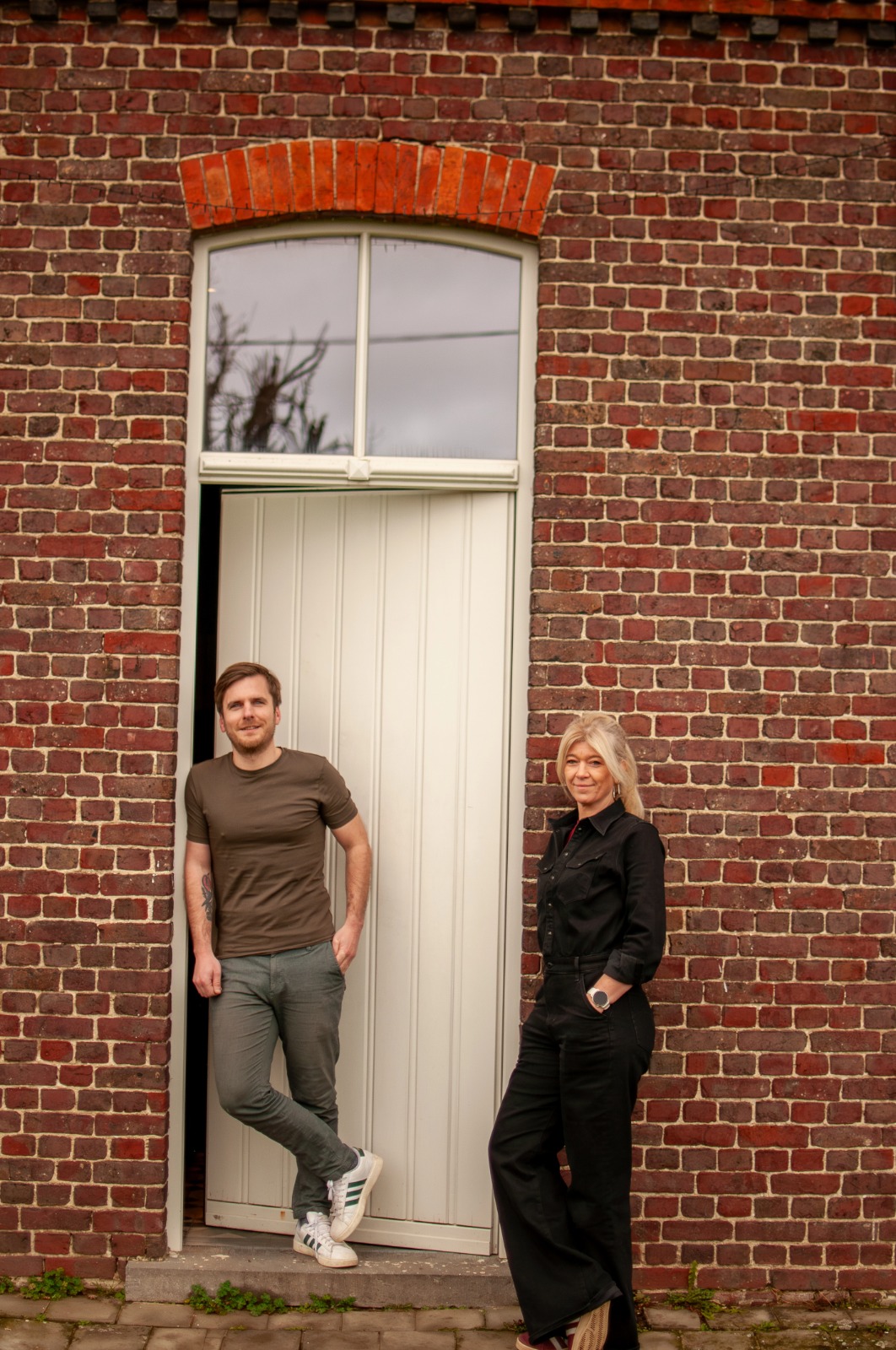 Stef en Sofie, de oprichters van INZICHT, staan bij de voordeur het INZICHT kantoor waar ze persoonlijke begeleiding bieden aan MAX-studenten.