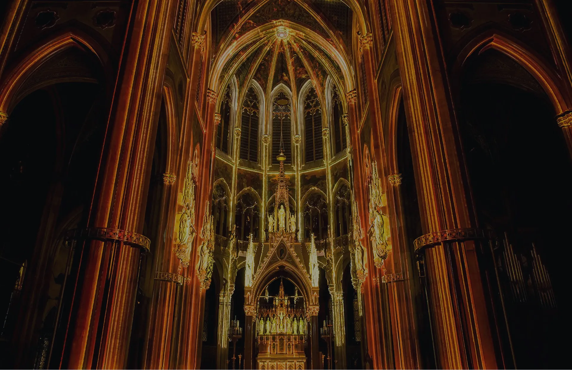 Golden light projection illuminating the interior of a grand Gothic cathedral, highlighting tall arches, intricate columns, and ornate statues with a warm, glowing effect.