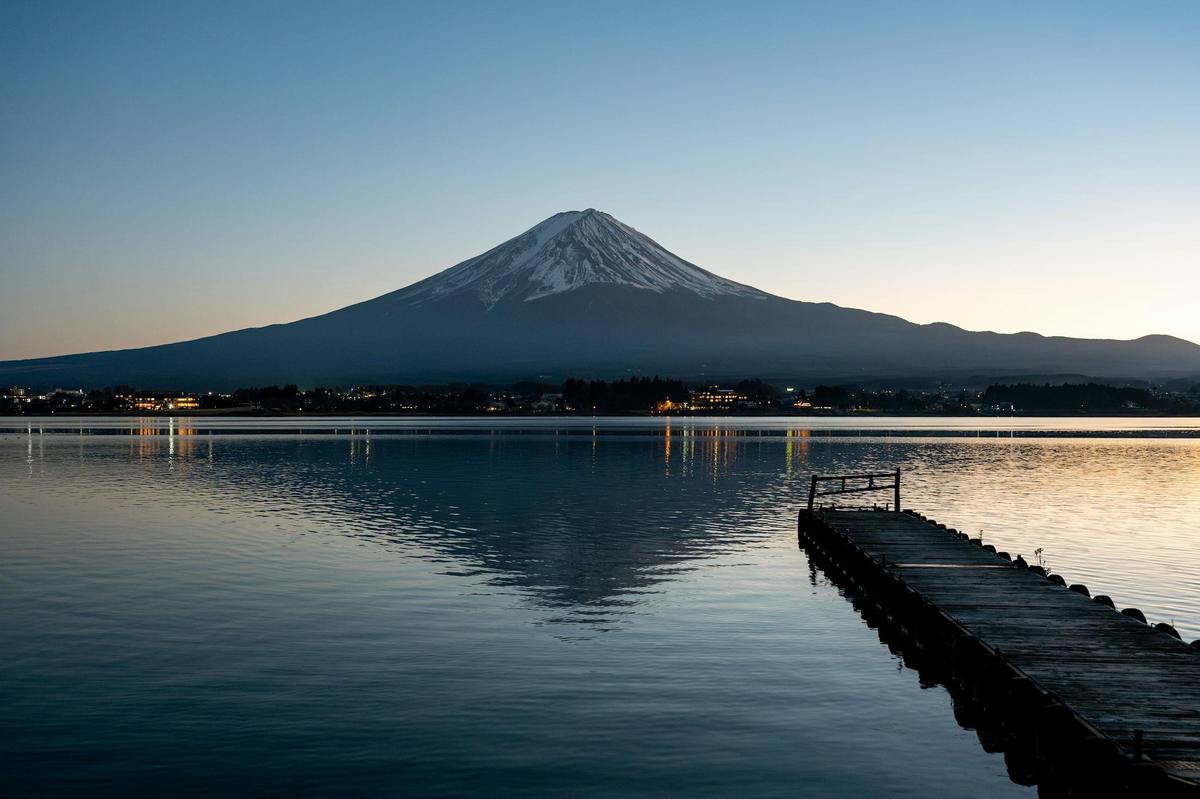 Mount Fuji reflected in a calm lake at dawn