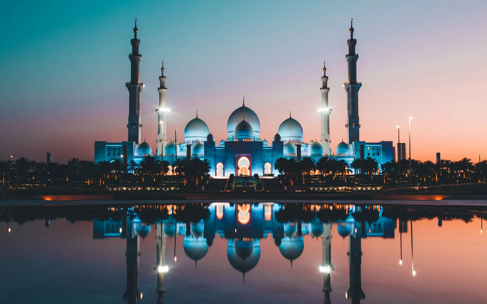 Die Scheich-Zayid-Moschee in Abu Dhabi spiegelt sich in der Dämmerung im Wasser