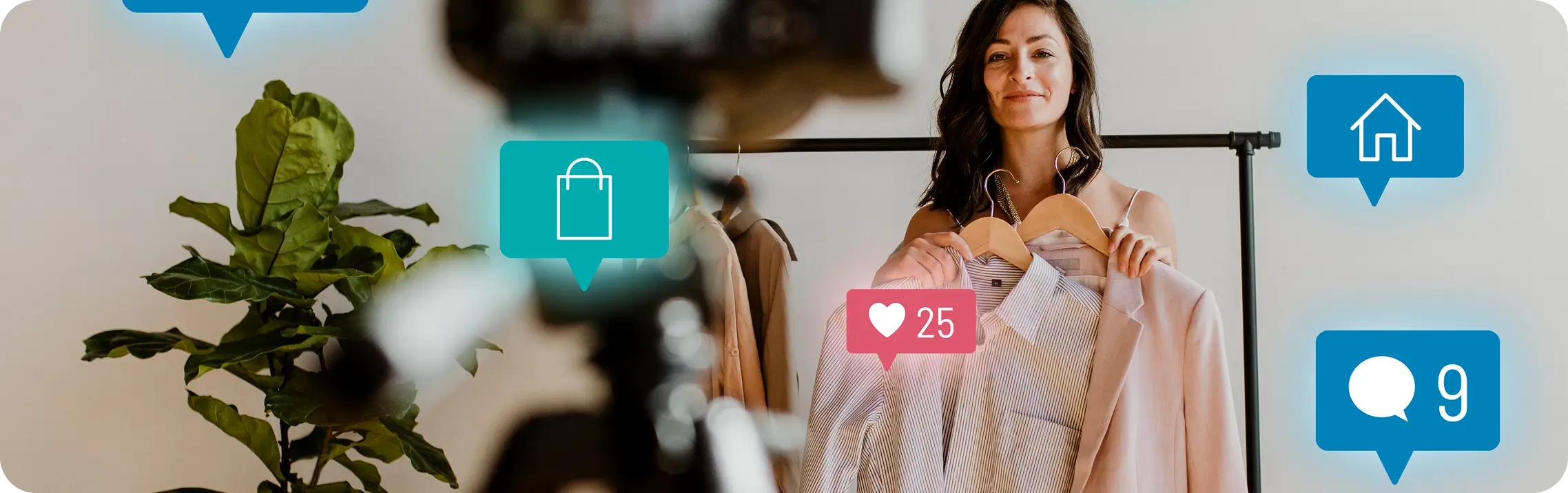 Four young professionals collaborating around a laptop at a wooden table in a modern office with a chalkboard and sticky notes in the background.