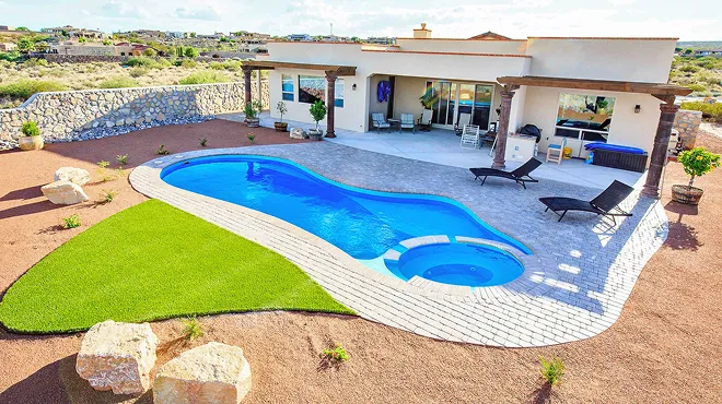 A house with a swimming pool in the middle of the yard.