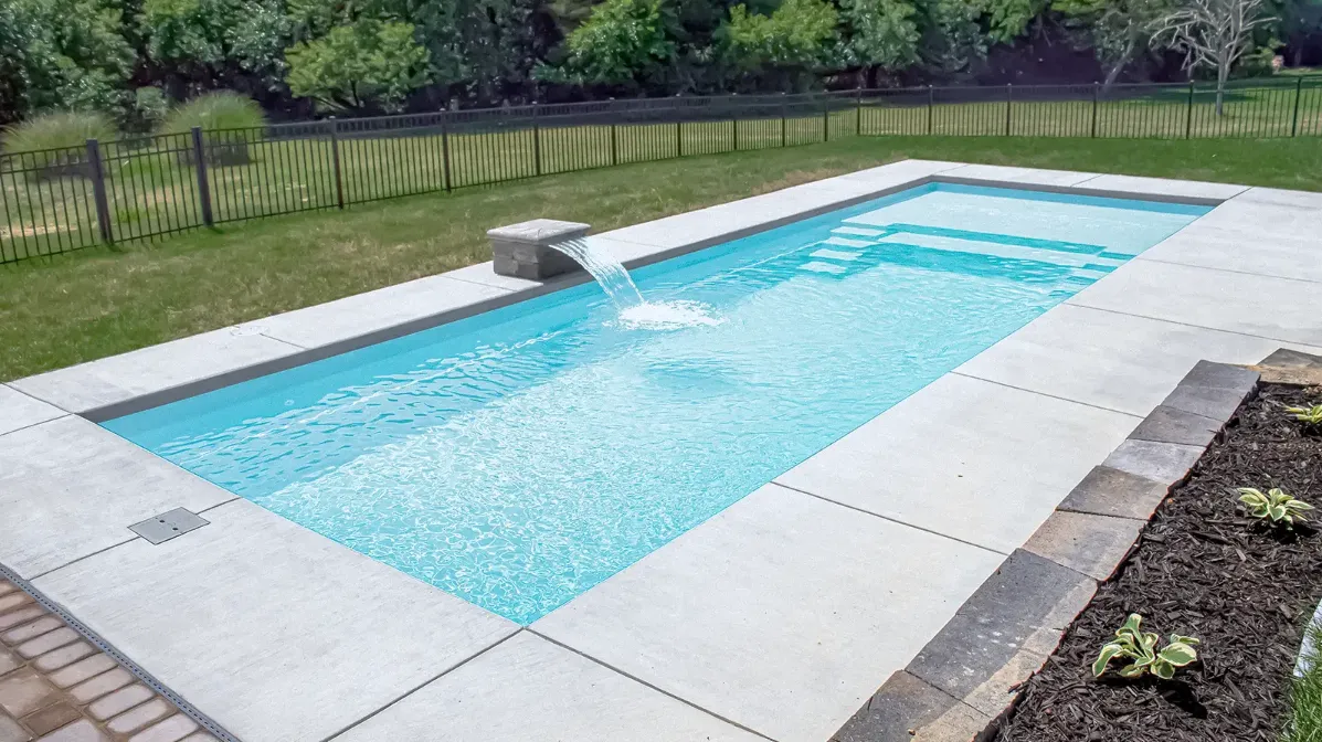 A swimming pool with a fountain in the middle of it.