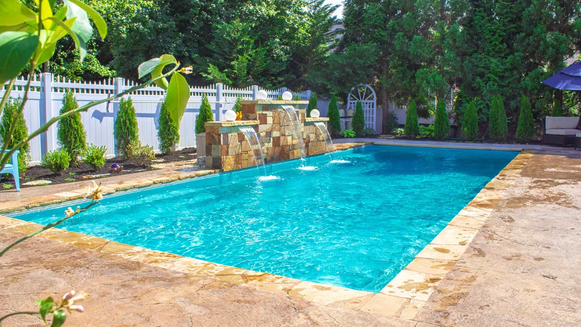 A pool with a waterfall in the middle of it.