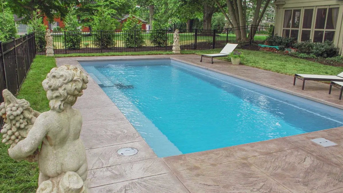 A small swimming pool with a statue next to it.