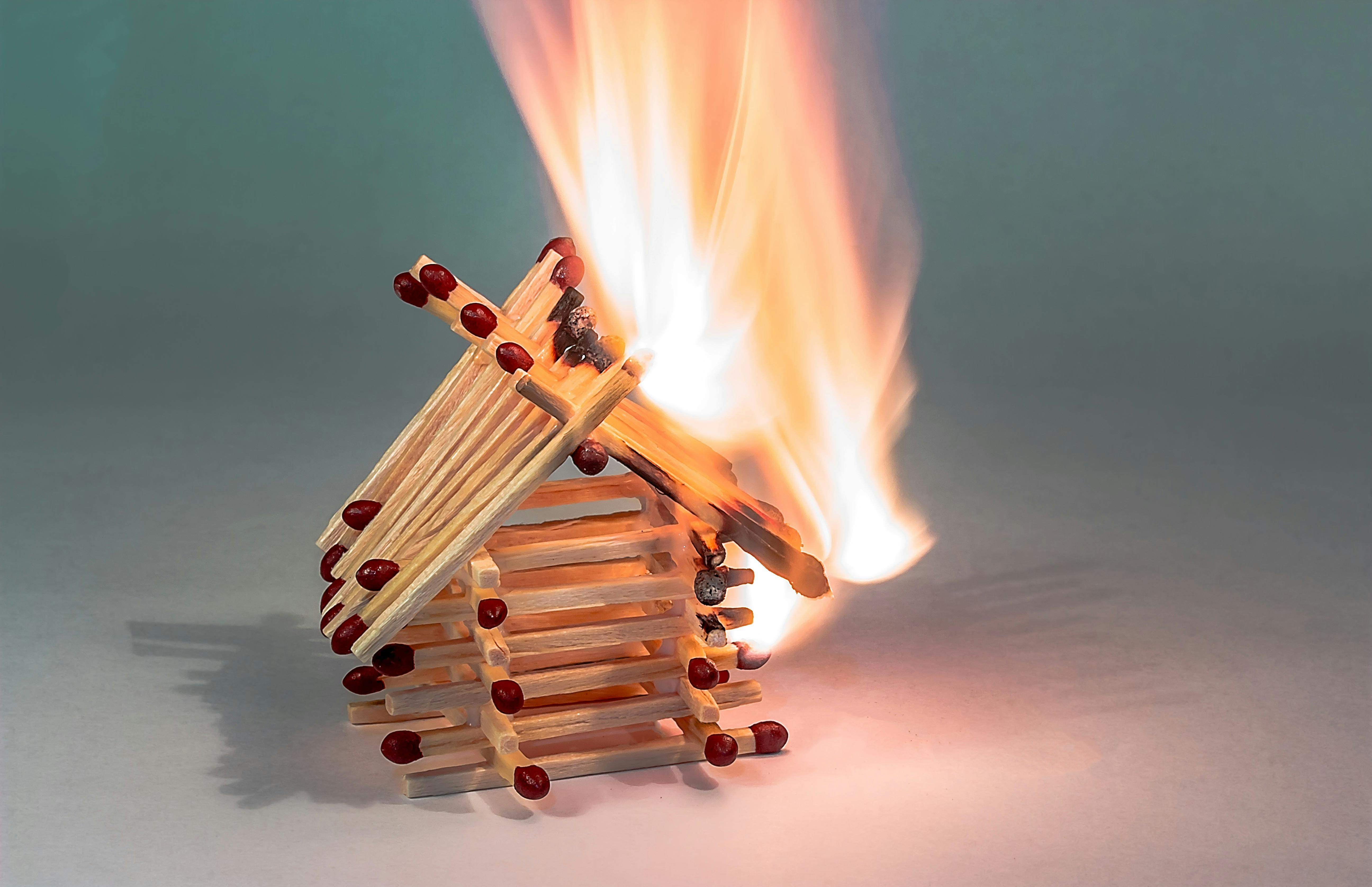 a burning matchstick house visualizing legal and ethical considerations in fire investigation forensic science
