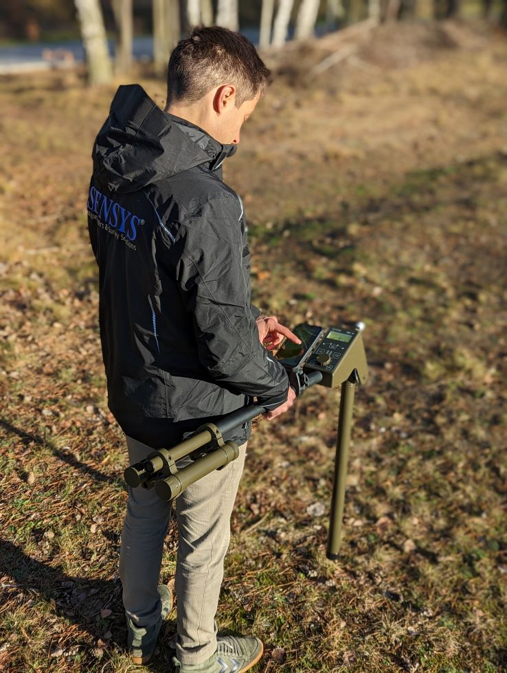 Mann bedient ein SENSYS Messgerät im Gelände.