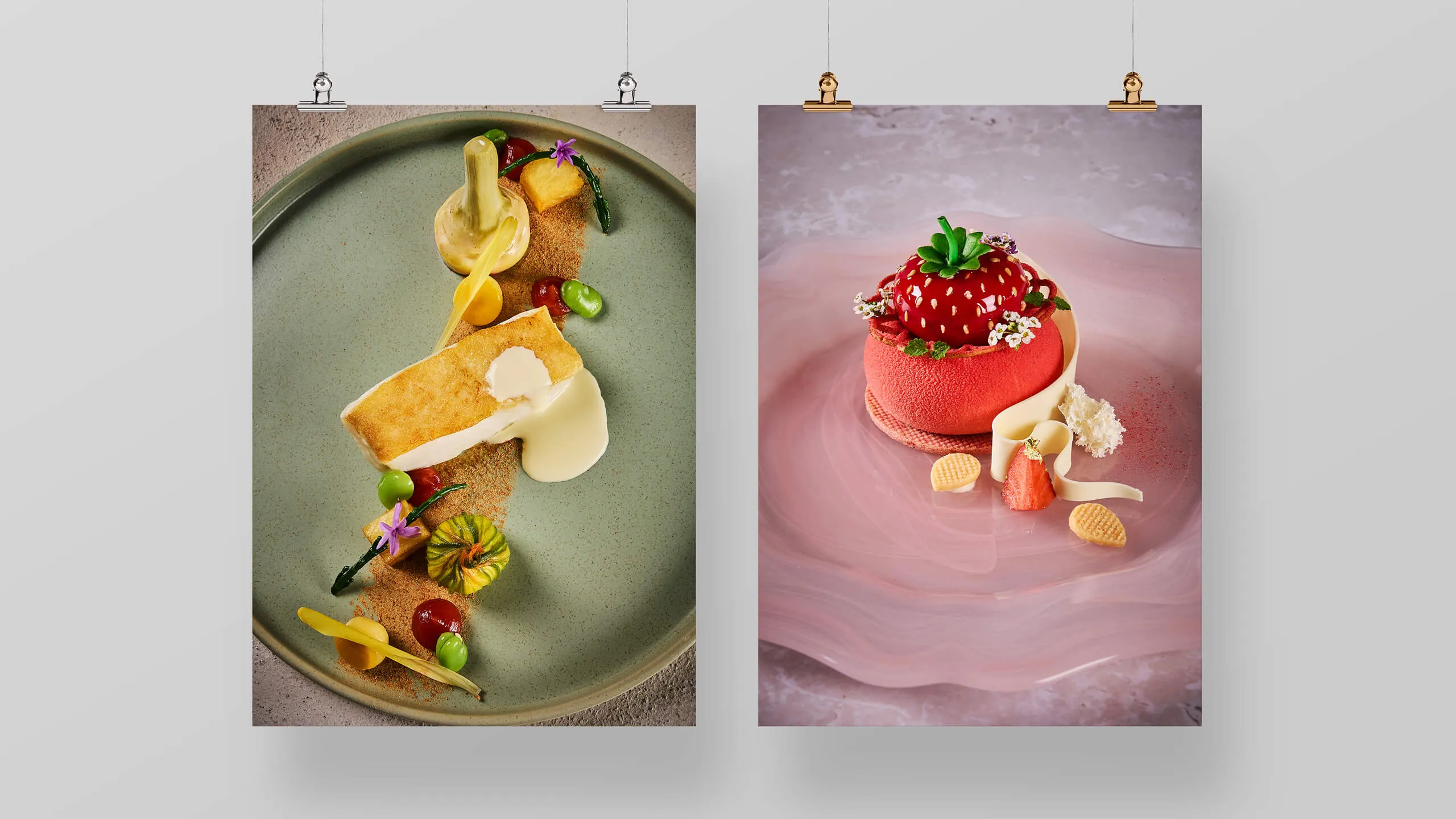 Two gourmet plated desserts: on the left, a rectangular cake with cream and colorful garnishes on a green plate; on the right, a round red dessert decorated to resemble a strawberry on a pink wavy plate.