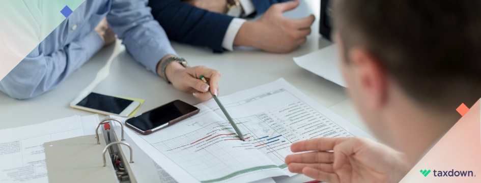Un asesor fiscal en una asesoría explicando a un cliente como hacer su declaración anual