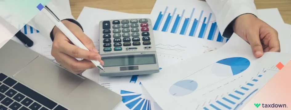 Una persona haciendo su declaración anual con un ordenador, papeles, boli y una calculadora