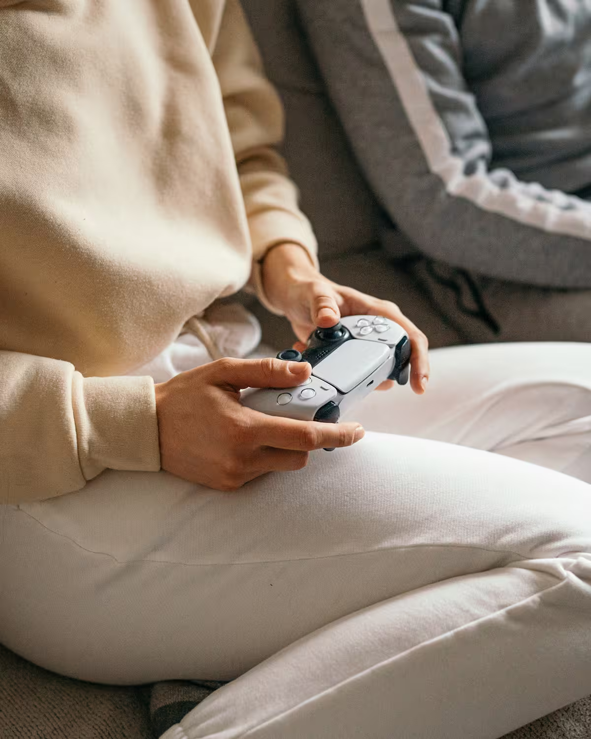 A woman holding a controller, playing a video game