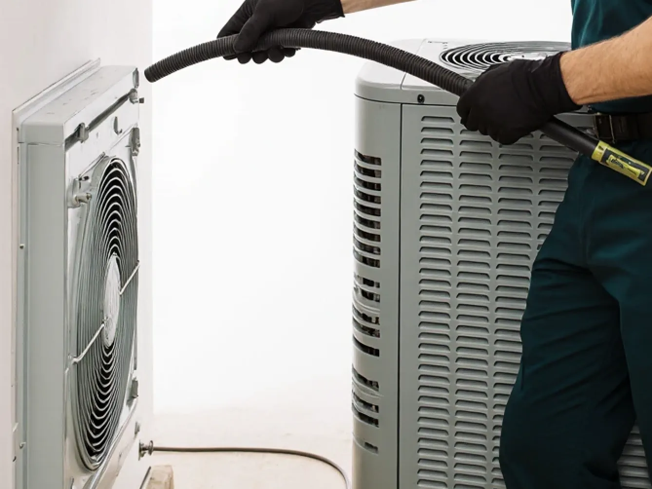 Technician connecting a hose to AC equipment