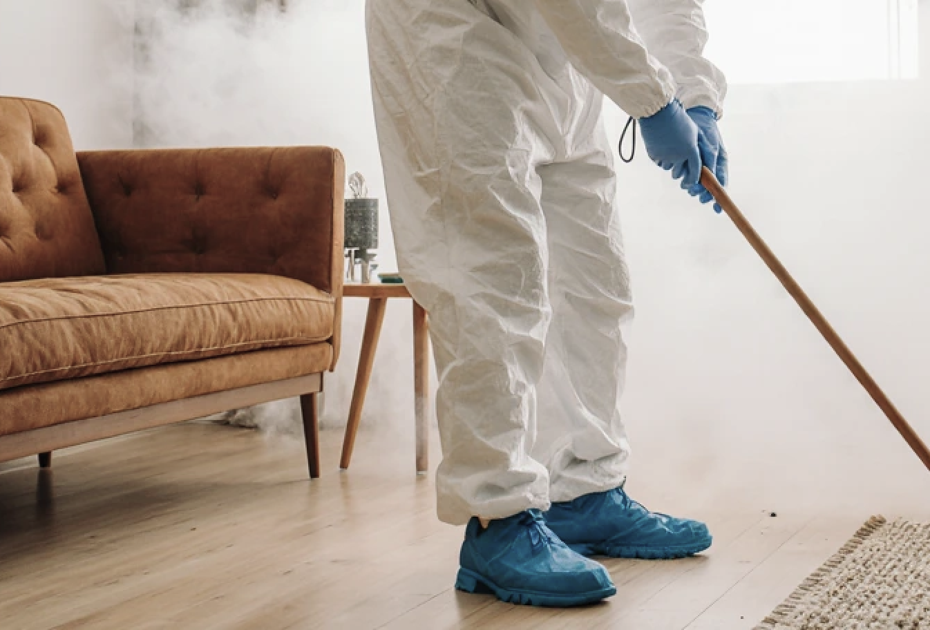Worker fumigating a living room