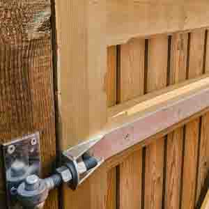 Softwood garden gate with curved top and latch, installed on brick wall boundary.