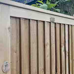 Slatted wooden pedestrian gate providing privacy and airflow between panels.