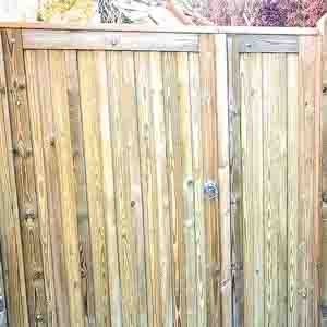 Closeboard pedestrian gate with top capping and natural wood finish.