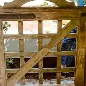 Picket-style wooden pedestrian gate with framed sides and curved top.