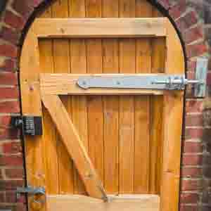 Arched top timber pedestrian gate with decorative frame and galvanised latch.