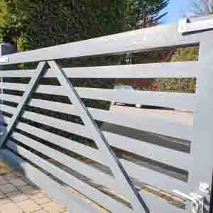 Modern white composite entrance gates with sleek horizontal panels and galvanised hinges.