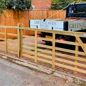 Timber entrance gates with closeboard design and matching fencing, offering privacy and strength.