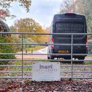 Five-bar entrance gate fitted with metal latch and posts, overlooking a country road.