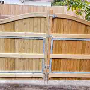 Double timber driveway gates with framed structure and natural stain finish.