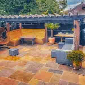 Contemporary timber pergola with integrated seating area and paved garden terrace.