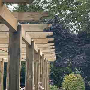Long wooden pergola walkway with evenly spaced posts and beams.