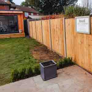 Pressure-treated vertical panel fence with smooth gravel board base for durability.
