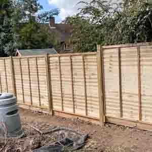 Timber panel fencing built on a retaining wall, blending security with smart garden design.