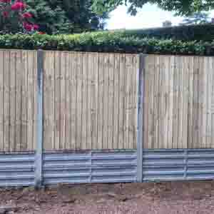 Vertical slatted timber panels with concrete posts and gravel boards for long-lasting support.