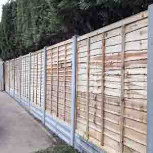 Overlap panel fencing with concrete posts for strength and weather resistance.