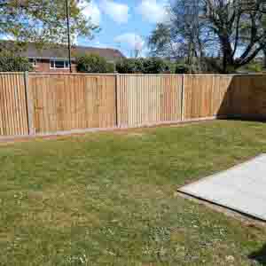 Timber fence with concrete posts and gravel boards providing a neat boundary by the driveway.