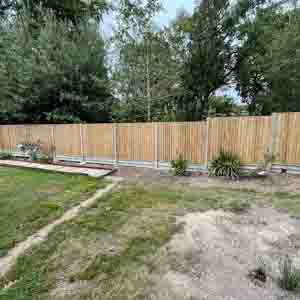 New garden boundary with concrete posts, gravel boards, and closeboard panels on level ground.